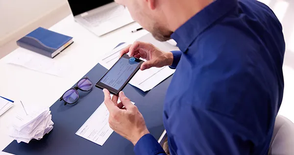 Depositing Money | Bank Reconciliation for Dental Clinics | Stellar Accounts Corp Business professional depositing money using a mobile banking app, symbolizing accurate EFT reconciliation for Canadian dental and medical clinics.