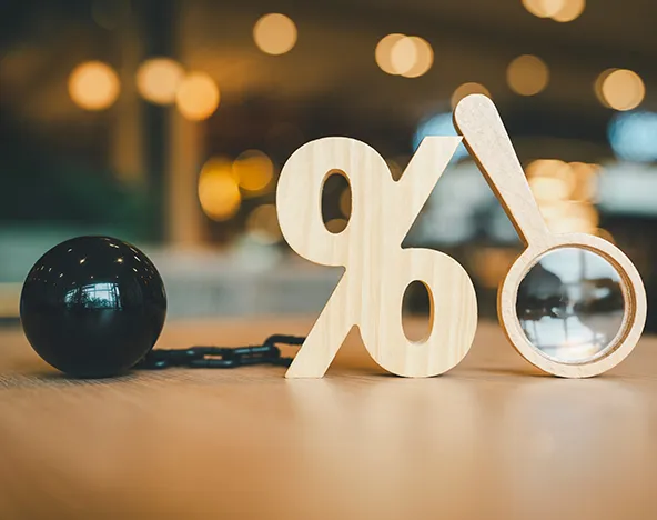 Reviewing Merchant Fees | Credit Card Processing Costs | Stellar Accounts Corp Percentage sign with magnifying glass symbolizing close examination of merchant and credit card processing fees for dental clinics.