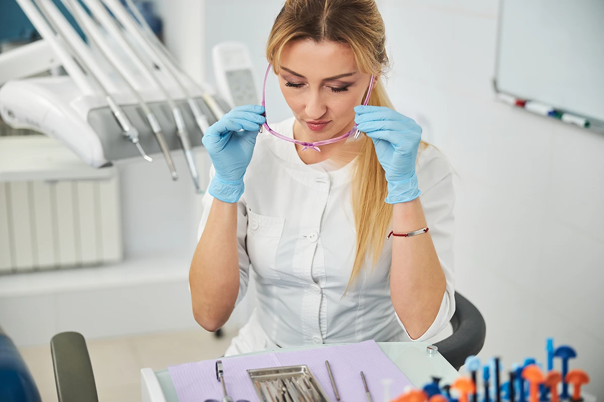 Dental hygienist setting up operatory before patient appointment — preparing instruments for a fully booked hygiene schedule.